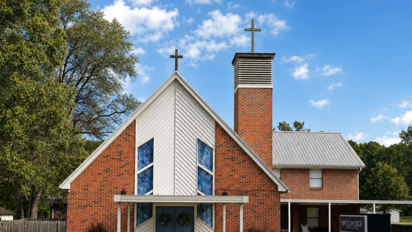 Brookside Church of God from Cardiff Street: red brick with a white gable, a bell tower, and two crosses.